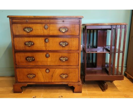 An Edwardian mahogany revolving bookcase, having two tiers with four sectional cases, on outstretched supports with ceramic c