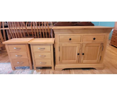 A modern solid light oak sideboard, having two frieze drawers over two cupboard doors opening to fitted shelf, on a skirted p