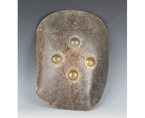 A 19th century Indian rhinoceros hide dhal shield, the front with four brass bosses, the back with carrying handles, diameter