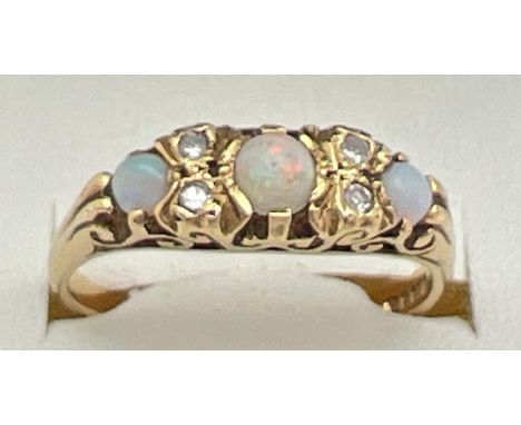 A Victorian style 18ct gold opal and diamond gypsy dress ring with pierced scroll design mount. Ring set with 3 graduating si