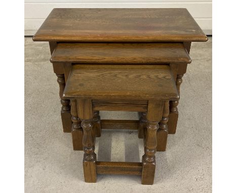 A vintage solid oak nest of 3 tables with turned design splayed legs. Approx. 45cm tall x 60cm long. 