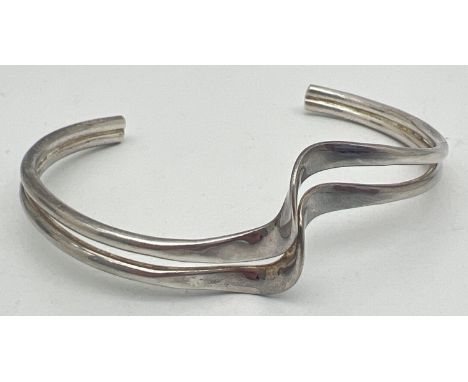 A silver modern design double wave style cuff bangle. Silver marks to inside. Total weight approx. 14.2g. 