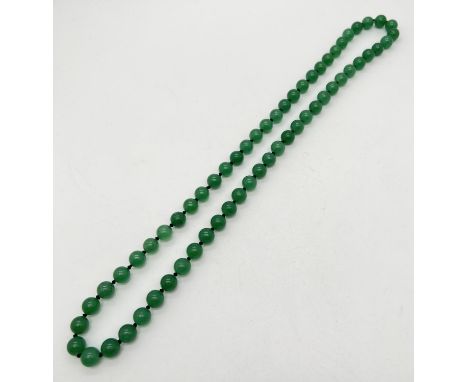 A 26" string of apple green jade beads, knotted between each bead. Beads approx. 1cm diameter. 