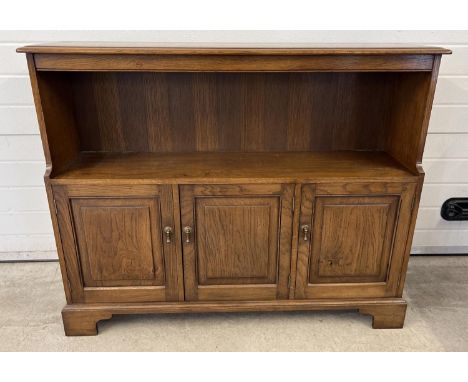 A vintage Simon Simpson, Norwich, solid dark oak bookcase with 3 door cupboard underside. Double and single cupboards with in