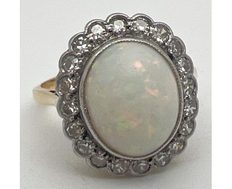 An opal and diamond 18ct gold dress ring. Central oval cut opal surrounded by 20 round cut small 0.02ct diamonds. Worn gold m