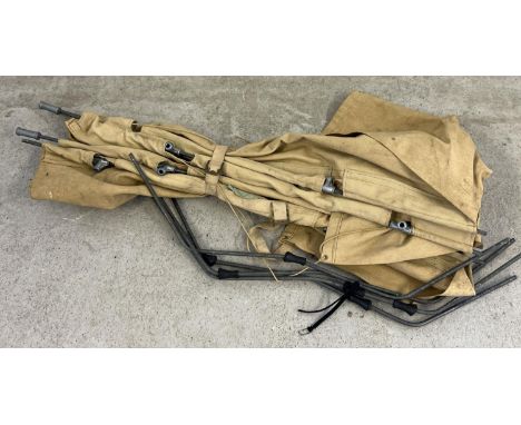 A vintage canvas and metal framed army bed with leg supports. 
