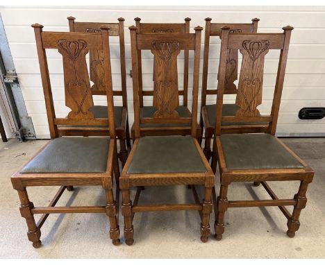 A set of 6 Art Nouveau dark oak dining chairs with turned legs and stylised carved backs. Turned front legs and faux leather 