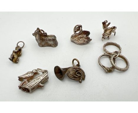 7 vintage silver and white metal charms. Comprising: triple rings, wise monkey, dog, deer with fawn, swan, woodpecker and Fre