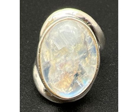 A modern design silver dress ring with twist style mount  set with a large moonstone cabochon. Silver mark to inside of band.