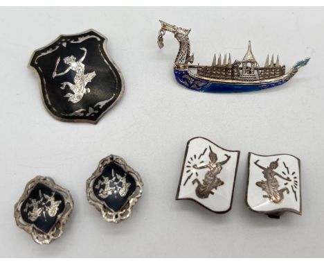 4 items of Siam silver jewellery. A dragon boat brooch with blue enamel detail; and a brooch, a pair of white enamel clip on 