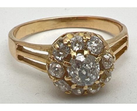 A vintage yellow gold 1ct diamond halo set cluster ring. Central round cut stone surrounded by 9 varying shaped diamonds. Pie