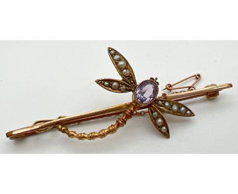 A vintage 9ct gold gem set dragonfly bar brooch with safety chain. Oval cut amethyst set to body with 4 wings set with seed p