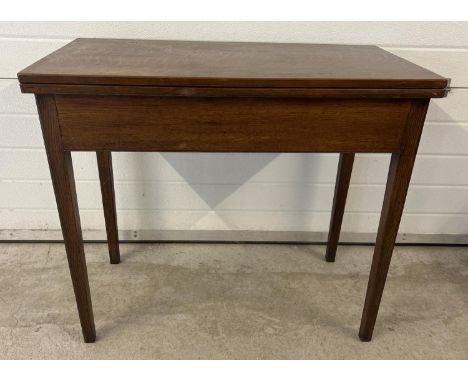 A vintage dark oak fold over tea table with square shaped taped legs and gate leg support. Approx. 77cm tall x 88cm wide. 