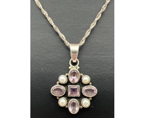 A modern design silver pendant set with round and square cut Rose De France amethysts and white freshwater pearls. On a 17" t