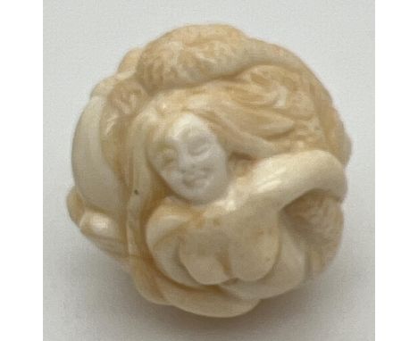 A carved bone netsuke of spherical form, carved as mermaids. Small signature mark to underside. Approx. 3.25cm diameter. 