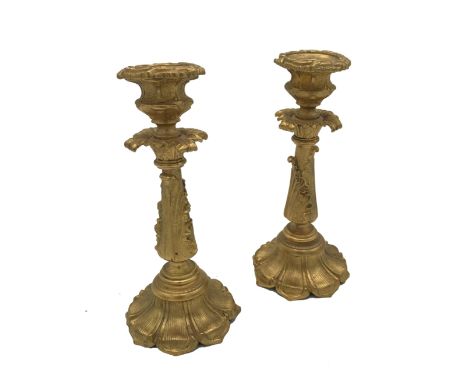 A PAIR OF VICTORIAN GILT BRONZE CANDLESTICKS, mid 19th century, each with foliate cast urn socket above a leafy quatreform dr