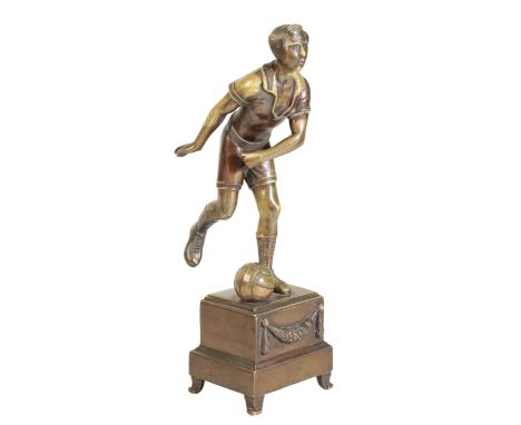 A CONTINENTAL BRONZE MODEL OF A FOOTBALLER, circa 1925, portrayed wearing open neck shirt, shorts, socks and boots, in the ac