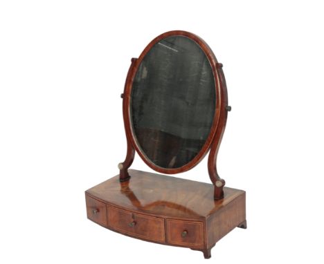 A GEORGE III MAHOGANY DRESSING TABLE MIRROR, circa 1800, the oval plate angle adjustable within twin serpentine supports, ris