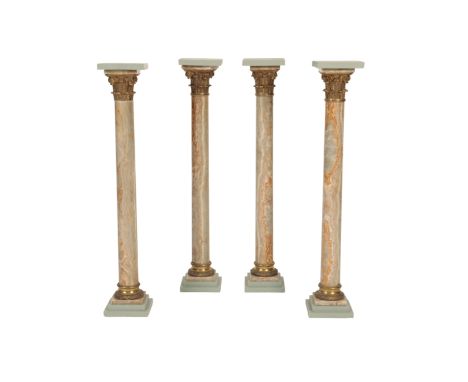 A SET OF FOUR EGYPTIAN STRIATED ALABASTER AND GILT BRONZE MOUNTED COLUMNAR PEDESTALS, late 19th century, with later painted s
