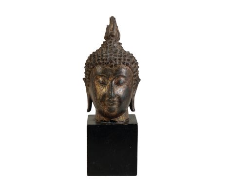 GILT-BRONZE HEAD OF A BUDDHA, THAILAND, 16TH CENTURY OR EARLIER the face in meditation with almond shaped eyes, the hair is a