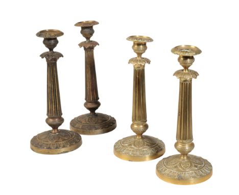 A MATCHED SET OF FOUR RESTAURATION GILT METAL CANDLESTICKS, circa 1830, each with foliate cast drip pan to an engine milled u