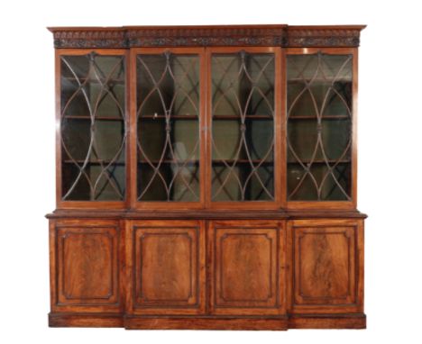 A GEORGE III MAHOGANY AND GLAZED BREAKFRONT BOOKCASE, late 18th /early 19th century, with Gothic arcaded cornice above a frie