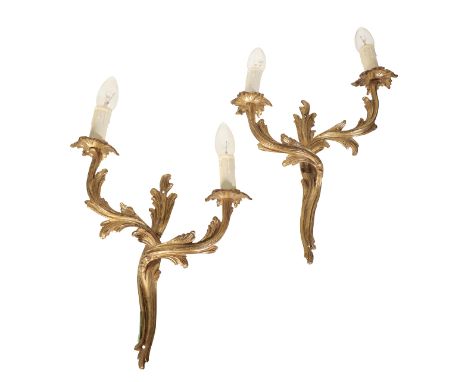 A PAIR OF ROCOCO STYLE GILT METAL WALL SCONCES each with two scrolling branches, fitted for electricity, 34cm high excluding 