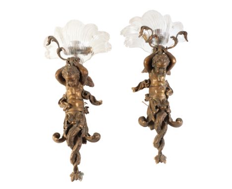 A PAIR OF GILT BRONZE AND GLASS FIGURAL WALL APPLIQUES, early 20th century, each with scallopshell moulded and cut glass shad