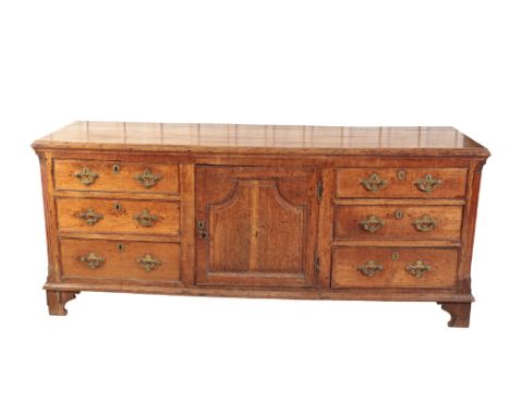 AN EARLY GEORGE III OAK DRESSER, circa 1770, the rectangular top with ogee moulded front and side edges, the central panel do