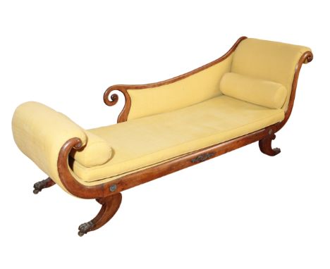 AN EMPIRE UPHOLSTERED AND STAINED HARDWOOD CHAISE LONGUE, early 19th century, with scrolled head and foot, the half-back with