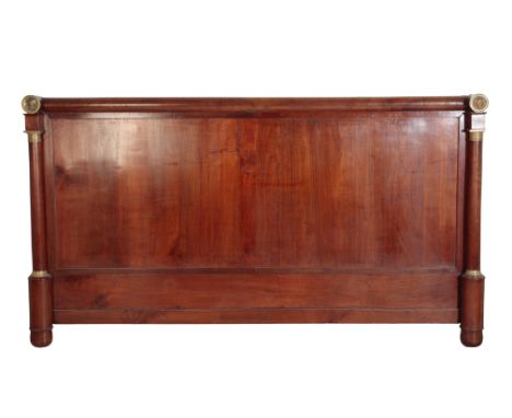 AN EMPIRE MAHOGANY AND ORMOLU MOUNTED HEADBOARD, early 19th century, the cylindrical toprail with a lateral cylinder finial a