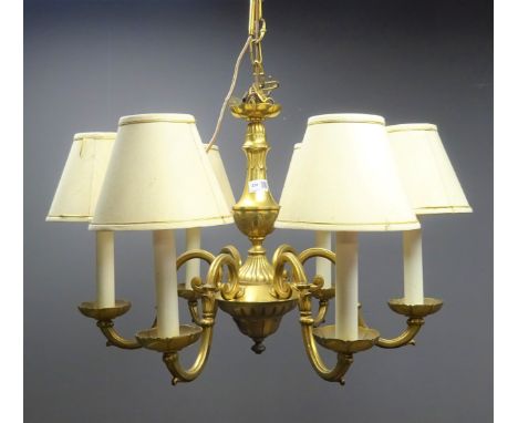 Brass chandelier with carved leaf detailing and six scrolled branches with fabric lampshades