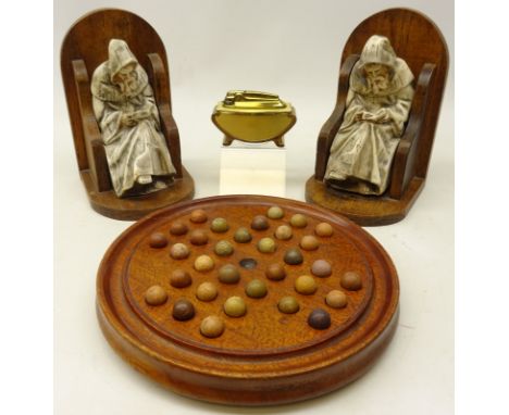 Early 20th century solitaire board on three feet complete with clay marbles, pair oak bookends with seated plaster of a druid