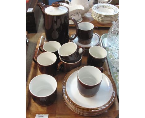 Poole Pottery coffee set on a brown ground comprising: coffee cups and saucers; cream jug; sucrier; coffee pot and plates.