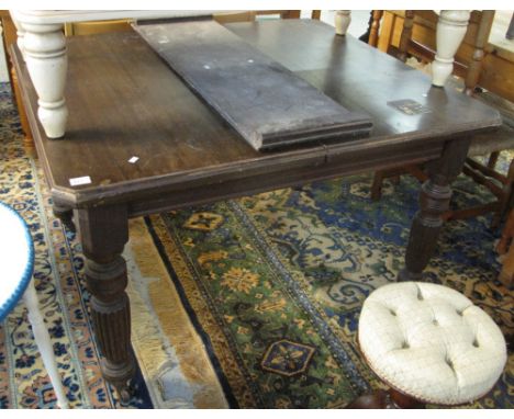 Early 20th Century stained mahogany extending dining table on ring turned and fluted legs and casters.