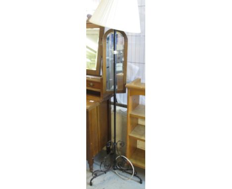 Wrought iron scroll decorated tripod standard lamp.