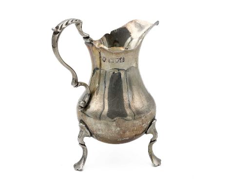 A George V silver milk jug by Haseler Brothers Of baluster form with a leaf and scroll handle, raised on three hoof feet. Dat