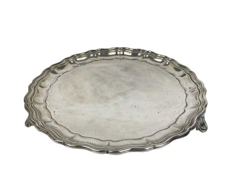 A George V silver salver by Martin Hall &amp; Co Ltd shaped circular outline, with a moulded border, raised on 3 feet. Dated 