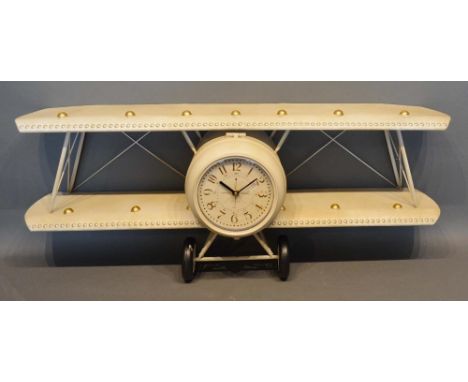 A Patinated Metal Wall Clock in the form of a bi-plane, with Arabic numerals, 90cm wide 