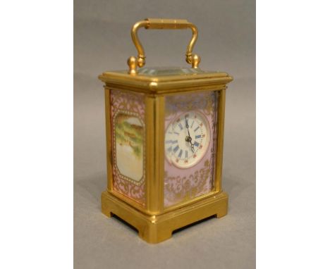 A French Brass Cased Carriage Clock with porcelain panels, the enamel dial with Roman and Arabic numerals and with lever esca