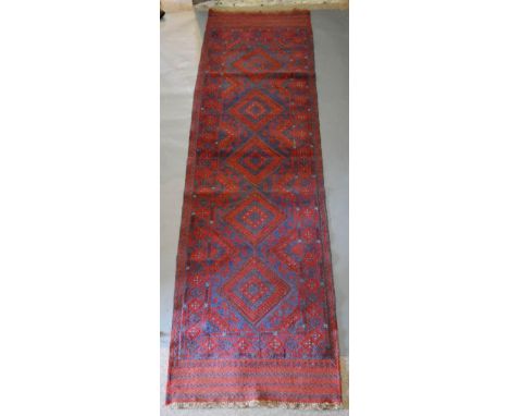 A North West Persian Woollen Runner with an allover design upon a red and blue ground within multiple borders, 260 x 67cm 