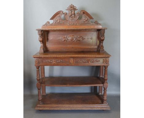 A Victorian Carved Oak Buffet, the shelf back above two frieze drawers above an undertier with turned supports, 124cm wide, 4