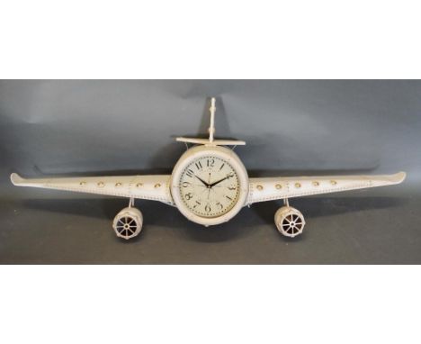 A Patinated Metal Wall Clock in the form of an aeroplane, the dial with Arabic numerals, 143cm wide 