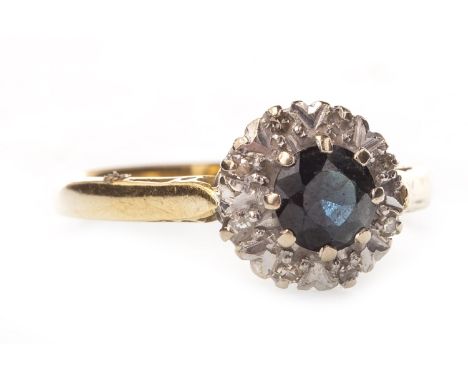 BLUE GEM AND DIAMOND CLUSTER RING, the central round faceted blue gem surrounded by illusion set diamonds, in eighteen carat 