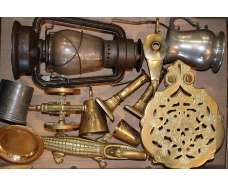 A mixed collection of brass and metalware items to include, storm lamp, Victorian trivet and various other items. (Qty)