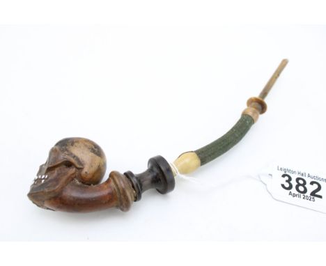 19th century hand-carved pipe with bowl in the form of a skull with inlaid porcelian/ceramic teeth and horn mouth piece, leng