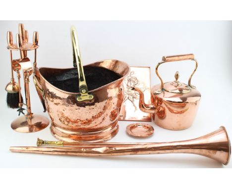 A collection of late 19th / early c20th copper metalware including an acorn top kettle, a fireside companion set, coal scuttl