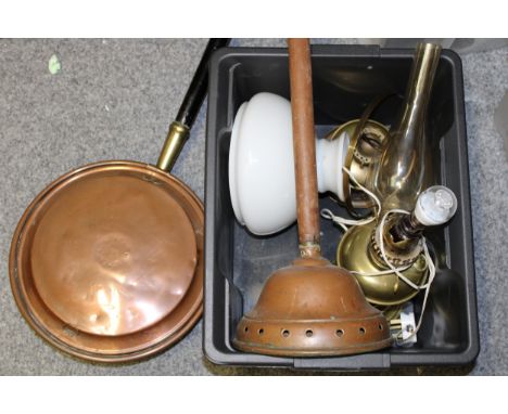 A collection of metalware to include a copper bed warming pan, copper posser and a brass oil lamp converted to an electric la