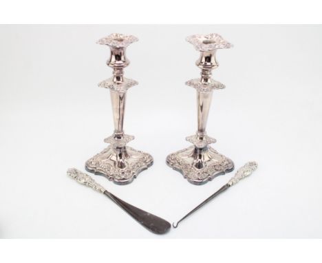 A silver handled button hook and a shoe horn, with large plated candlesticks, 27cm tall (4).