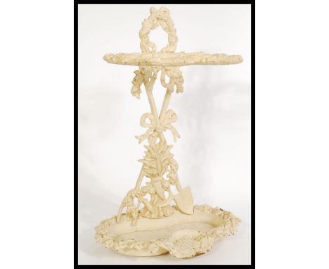 A Victorian white painted cast iron walking stick / umbrella stand with decorative bows and garlands and drip tray to the bas